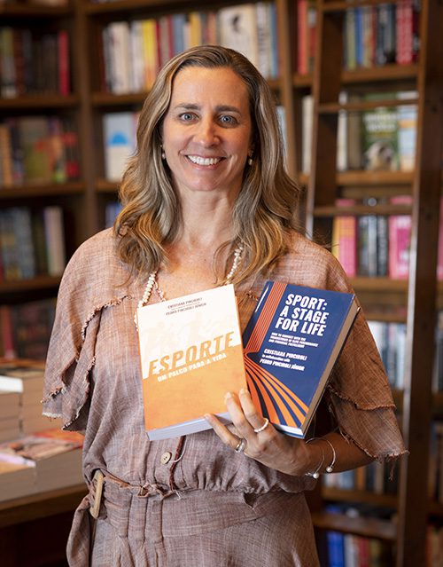 Cris Pinciroli holdind the portuguese and english versions of her book, Sport: a Stage for Life